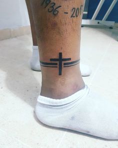 a person with a cross tattoo on their foot and the words jesus christ written in black ink