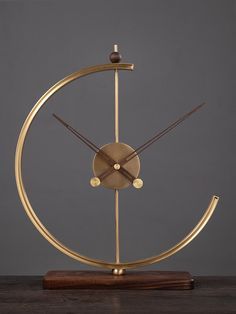 a golden clock on top of a wooden table