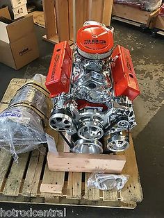 an orange engine sitting on top of a wooden pallet