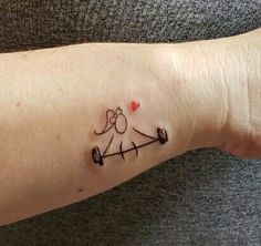 a small tattoo on the arm of a person with an arrow and heart in it