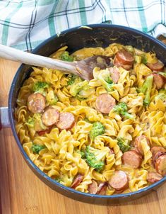 a skillet filled with pasta, sausage and broccoli