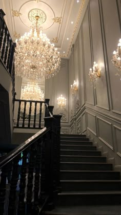 an elegant staircase with chandeliers and lights