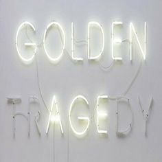 a white wall with neon lights and the words golden angel written in black on it