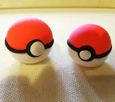 two pokeballs sitting on top of a white cloth covered table next to each other