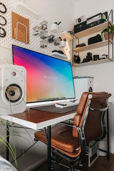 a computer monitor sitting on top of a desk next to a speaker and speakers in front of it