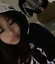 a woman with long hair wearing a skeleton hoodie