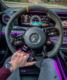 a man is driving his car with the steering wheel and gauges on display in front of him