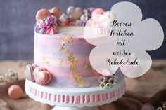 there is a pink cake with gold decorations on the top and bottom, along with words above it