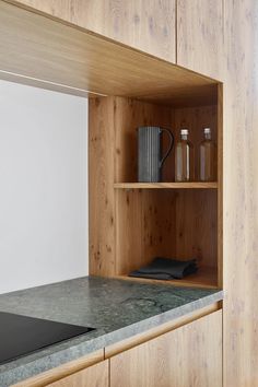 a kitchen counter top with wooden cabinets and shelves