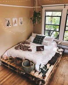 a bed made out of pallets with pillows and blankets on it in a bedroom