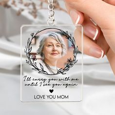 a woman's hand holding a keychain with an image of the queen on it