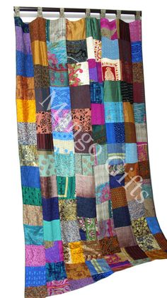 a multicolored quilt hanging on the side of a wall