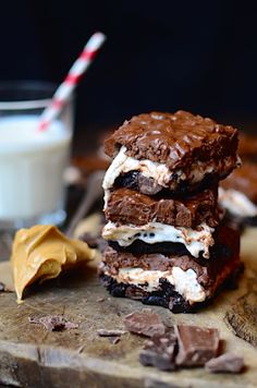 three pieces of chocolate ice cream sandwich on a cutting board next to a glass of milk