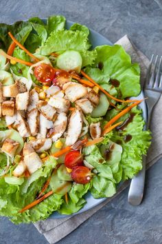 a salad with chicken, carrots and lettuce