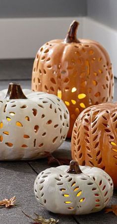 carved pumpkins are sitting on the floor next to each other with holes in them