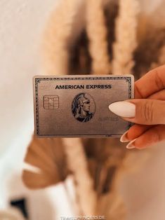 a woman holding an american express card in her hand