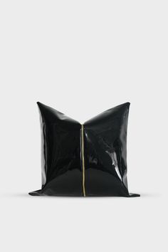 a black pillow sitting on top of a white floor