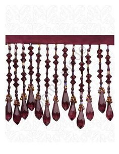 a red and gold chandelier hanging from a wooden rod with crystal drops on it