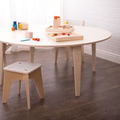 a white table with two chairs and toys on top of it in front of a window