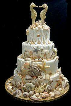 a three tiered cake decorated with sea shells