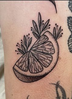 a black and white photo of a piece of fruit on the side of a woman's leg