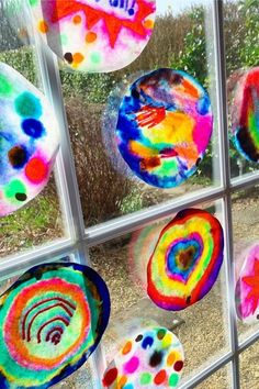 colorful paper plates are hanging in a window