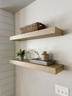 two wooden shelves with baskets and flowers on them