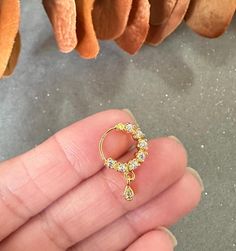 a person is holding a gold ring in their left hand and some oranges on the other side