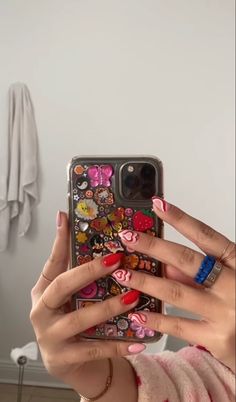 a woman taking a selfie with her phone case covered in many different stickers