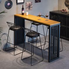 a table with two chairs and a wine glass on it in front of a wall