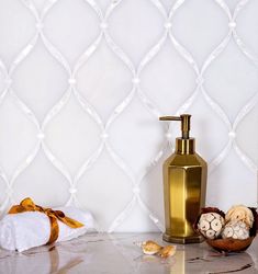 a gold soap dispenser sitting on top of a counter next to a white towel