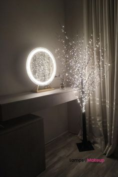 a lighted tree in front of a mirror with lights on it and a light up branch