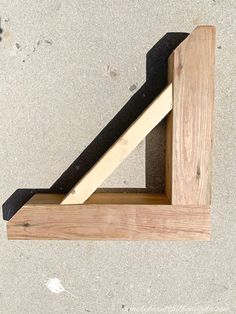 a piece of wood sitting on top of a cement floor next to a wooden frame