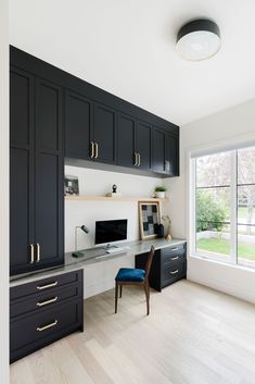 a home office with black cabinets and white walls