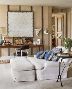 a living room filled with furniture and a painting on the wall