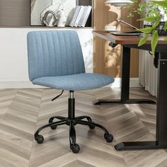 a blue office chair sitting on top of a hard wood floor next to a desk