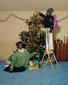 a woman sitting in front of a christmas tree