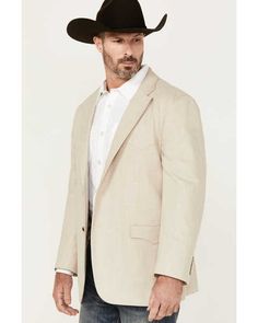 a man wearing a cowboy hat standing in front of a white background and looking at the camera