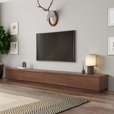 a large flat screen tv mounted to the side of a wooden entertainment center in a living room