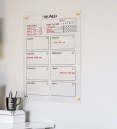 a white board with some writing on it next to a coffee mug and pen holder