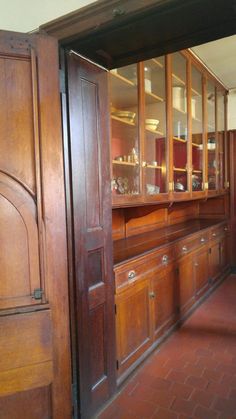 an old fashioned kitchen with wooden cabinets and tile flooring