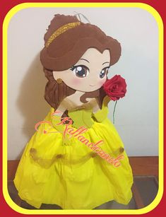 a stuffed doll wearing a yellow dress and holding a red rose