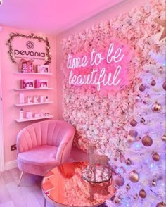 a room with pink furniture and flowers on the wall, along with a neon sign that says welcome to be beautiful