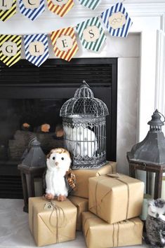 there is a small owl sitting on top of some presents in front of the fireplace