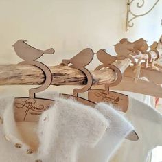 several wooden birds on clothes hangers in a room