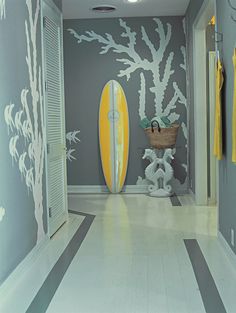 the hallway is decorated in gray and white with yellow surfboards on the wall next to it