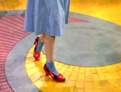 a woman in blue dress and red shoes