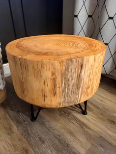 a wooden table sitting on top of a hard wood floor next to a rug and vase