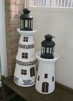 two decorative lighthouses sitting on top of a wooden bench