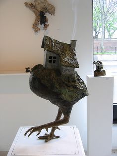 a sculpture of a bird with a house on it's back